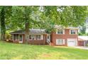 Lovely red brick home with green lawn, shade trees, and a welcoming front porch at 1558 Boulderwoods Se Dr, Atlanta, GA 30316