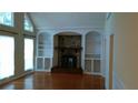 Cozy living room with a stone fireplace, built-in shelves, and large windows at 2297 Horseshoe Bend Sw Rd, Marietta, GA 30064