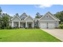 Exterior shot of gray single story house with two-car garage, welcoming covered porch, and pristine landscaping at 287 Flower Farm Dr, Acworth, GA 30101