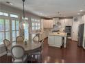 Spacious eat-in kitchen with white cabinets, stainless steel appliances, a center island, and a wooden dining table set at 970 Tarpley Nw Rd, Kennesaw, GA 30152