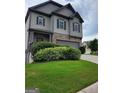 Charming two-story home featuring stone accents, gray siding and a well-manicured lawn at 2424 Saint Andrews Rdg, College Park, GA 30337