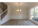 Bright dining room featuring hardwood floors, wainscoting, and a modern chandelier at 2346 Hampton Park Dr, Buford, GA 30519