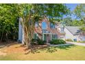 Traditional brick home with blue shutters, a manicured lawn, and lush landscaping at 2346 Hampton Park Dr, Buford, GA 30519