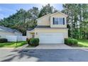 Charming two-story home with a two-car garage, manicured lawn and mature trees at 609 Bedford Court, Woodstock, GA 30188