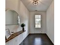 Inviting foyer with dark hardwood floors, a stylish mirror, decorative table and clear view of the front door at 4583 Roskin St, Duluth, GA 30097