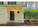 Inviting front entrance featuring a black door with a sidelight and manicured landscaping at 658 Slew Ave, Lawrenceville, GA 30043