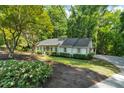 Well-maintained exterior with a lush green lawn, meticulous landscaping, and a charming light-colored facade at 1590 Sunnybrook Farm Rd, Atlanta, GA 30350