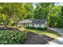 Attractive single-story home with mature landscaping, driveway, and lush green surroundings at 1590 Sunnybrook Farm Rd, Atlanta, GA 30350