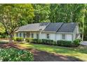 Attractive one-story home with a driveway, gray roof, manicured landscaping, and inviting curb appeal at 1590 Sunnybrook Farm Rd, Atlanta, GA 30350