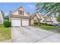 Home exterior with a two-car garage, well-kept lawn, and attractive landscaping in a residential neighborhood at 918 Harvest Brook Dr, Lawrenceville, GA 30043