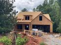 Framed house under construction shows its dormer and the structure before siding or brick is applied at 6134 Linwood Dr, Covington, GA 30014