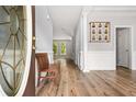 Bright foyer with light gray walls, wood floors, decorative molding, and a wooden bench at 507 Mirramont Pl, Woodstock, GA 30189