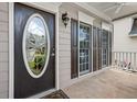 Close-up of the front door and porch of the home showing detailed trim and windows with brown shutters at 507 Mirramont Pl, Woodstock, GA 30189