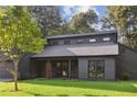 Striking modern home with dark wood siding, a well-manicured lawn, and stylish windows under a cloudy sky at 600 Applewood Nw Ln, Marietta, GA 30064