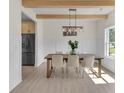 Light-filled dining room with wood beams, wainscoting, modern lighting, and stainless steel appliances in view at 1128 E Shoreview Rd, Mcdonough, GA 30253