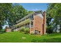 Two-story brick home featuring a welcoming front porch, gable roof, and lush green lawn at 3835 Thornhill Sw Dr, Lilburn, GA 30047
