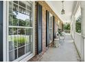 Inviting covered front porch with white railings and classic brick accents offering a serene outdoor living space at 3835 Thornhill Sw Dr, Lilburn, GA 30047