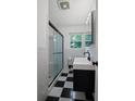 Modern bathroom showcasing sleek black and white tiles and a glass enclosed shower at 4051 Dixie Ln, Douglasville, GA 30135