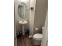 Cozy half bathroom with a pedestal sink, hardwood floors, and chrome fixtures at 5752 Little River Rd, Atlanta, GA 30349
