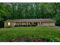Ranch-style home with well-maintained lawn, mature trees, and attached two-car garage at 7704 Holyoke Rd, Cumming, GA 30040