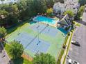 Overhead view of tennis courts next to pool, all surrounded by trees, parked cars and townhomes at 2345 Gallard St, Lawrenceville, GA 30043