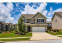 Two-story home featuring a well-maintained lawn, a two-car garage, and complemented by lush landscaping at 2486 Bear Mountain St, Lithonia, GA 30058