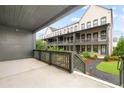 Back porch view of townhomes with landscaped lawns, mulch beds, and manicured shrubs at 6710 Pippin Walk, Alpharetta, GA 30005