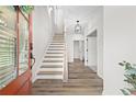 Bright foyer with wood floors, stairs leading up, and an open doorway at 6710 Pippin Walk, Alpharetta, GA 30005