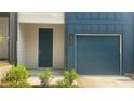 A blue townhouse with a front door and garage, and the address number displayed at 1615 Gunnin Nw Trce, Atlanta, GA 30318