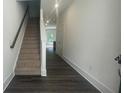 View of a hallway with wood floors, a staircase, and a door leading to another room at 1615 Gunnin Nw Trce, Atlanta, GA 30318