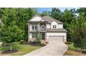 Inviting two-story home with a manicured lawn, attached garage, and charming balcony at 4814 Little Cove Ct, Auburn, GA 30011