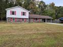 Exterior of charming split-level home with brick and siding, plus a large front lawn and carport at 7437 Grayson Dr, Riverdale, GA 30296