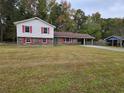 Charming split-level home with brick accents, red shutters, and a spacious front lawn at 7437 Grayson Dr, Riverdale, GA 30296