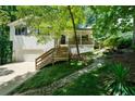 Beautiful home with wooden porch, stairs, and lush landscaping, complemented by a charming stone-lined drainage at 86 Kelly Ct, Dallas, GA 30157