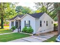 The exterior view of the home shows great curb appeal and concrete driveway in a luscious, green neighborhood at 3143 Church St, East Point, GA 30344