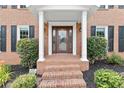 Close-up of the front porch with brick steps, white pillars and a stained wood front door at 4211 Schooner Ne Ct, Roswell, GA 30075