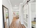 Bright entryway with wood floors, a large mirror, and sliding barn doors leading to other rooms in the house at 515 Cobblestone Ct, Canton, GA 30115