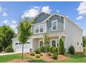 A charming two-story home featuring manicured landscaping and a blend of gray and white tones under a bright sky at 515 Cobblestone Ct, Canton, GA 30115
