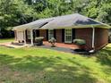 Beautiful brick home with black shutters and a manicured lawn, set against a wooded backdrop at 7400 Little Fawn Pkwy, Palmetto, GA 30268