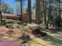 Charming home featuring flowering shrubs, mature trees, and a well-manicured lawn at 1534 Cooper Lake Se Rd, Smyrna, GA 30082