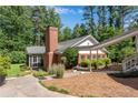 Well-maintained exterior with a brick chimney and a cozy screened-in porch, complemented by lush landscaping at 435 Old Holly Rd, Milton, GA 30075