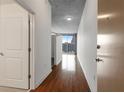 Hallway featuring hardwood floors leading to a living area with a city view through large windows at 860 Peachtree Ne St # 1912, Atlanta, GA 30308