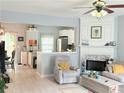 Cozy living room with fireplace, ceiling fan, and open view to the kitchen at 4172 Howell Park Road, Duluth, GA 30096