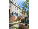 Townhome facade with blue shutters, brick entry stairs, and mature landscaping on a sunny day at 6459 Chariot St # 35, Atlanta, GA 30328