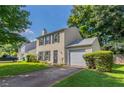 View of home with green yard, dark shutters, one-car garage, and paved driveway at 1377 Mill Lake Cir, Stone Mountain, GA 30088