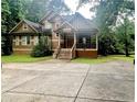 Charming two-story home with a welcoming front porch and well-manicured lawn surrounded by lush trees at 2961 River Ridge Drive Sw, Atlanta, GA 30354