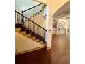 Elegant foyer with a hardwood floor, staircase with wrought iron railing, and arched doorway leading to the kitchen at 2961 River Ridge Drive Sw, Atlanta, GA 30354