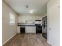 Efficient kitchen features white cabinets, dark appliances, and modern wood flooring at 2783 Bicentennial Dr, Stone Mountain, GA 30087