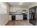 Functional kitchen featuring white cabinets and modern wood flooring at 2783 Bicentennial Dr, Stone Mountain, GA 30087
