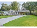 Inviting exterior featuring a well-kept lawn, carport, and a welcoming facade with a brick foundation at 130 Mimosa Dr, Fayetteville, GA 30214